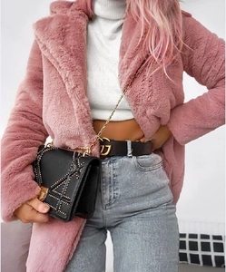 Detailed look at luxury pink faux fur coat paired with a designer belt and a black handbag