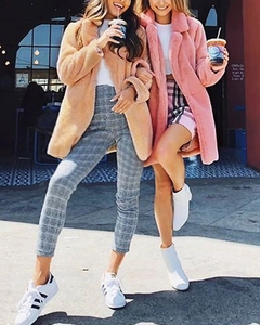 Close-up of loose faux fur coats in khaki and pink styled for women's autumn winter fashion