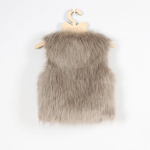 Détail d'un gilet en fausse fourrure marron clair pour enfant avec texture longue et duveteuse