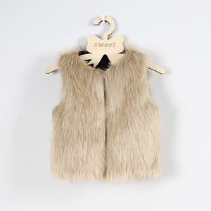 Détail rapproché d'un gilet en fausse fourrure beige pour enfant sur un cintre en bois