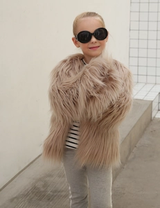 Detail of soft faux fur texture on children's winter coat in light beige stylish look