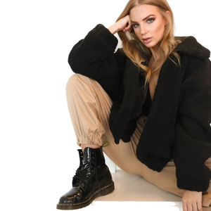 Close-up of black fuzzy faux shearling jacket with large lapels on a fashion model