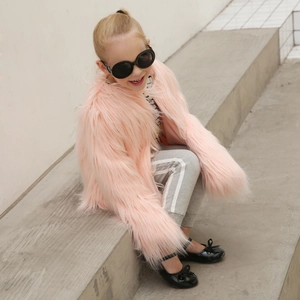 Detail of child wearing a pink faux fur coat with long fluffy texture and soft lining