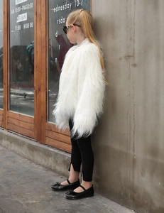 Detail of white faux fur coat for kids with high fluffiness and long sleeve texture