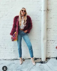 Scatto street style di giacca corta bordeaux in piume di struzzo con trama soffice