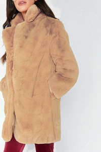 Detailed side view of camel faux fur coat with oversized lapel and plush texture