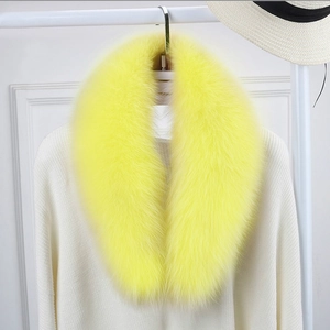 Detail of fluffy bright yellow faux fur scarf on a white knitted sweater texture