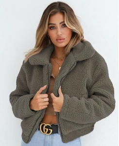 Close-up of thick fleece texture on faux lamb wool jacket with zipper and wide collar
