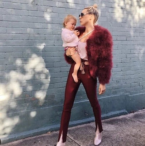 Stile street di una donna che indossa una giacca di pelliccia sintetica bordeaux e pantaloni