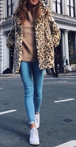 Faux fur leopard print coat styled with blue jeans and sneakers for a winter street look