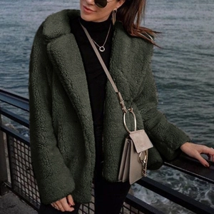 Detail view of dark olive green faux fur teddy coat with wide lapel collar and soft texture