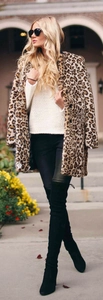 Street style shot of a woman in a leopard print faux fur coat and black over-the-knee boots