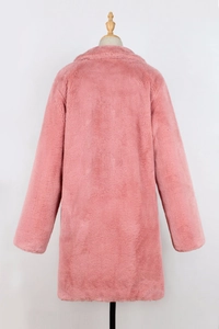 Detail of pink faux fur coat featuring thick plush texture and elegant wide lapel design