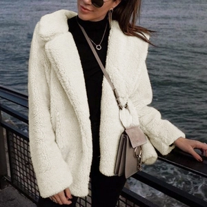 Detail showing plush cream faux fur texture and lapel collar of the teddy coat