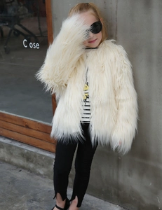 Close-up of children's faux fur coat in cream white featuring long shaggy plush texture