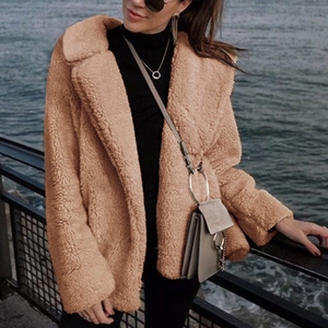 Detail of a brown teddy fur coat with a wide notch lapel and soft plush texture