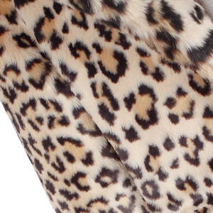 Close-up detail of soft faux fur leopard print fabric with fluffy texture and pattern