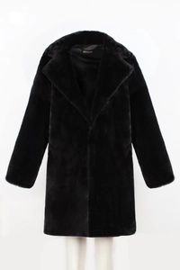 Detail showing the inner silk lining and brand label of a black faux fur coat