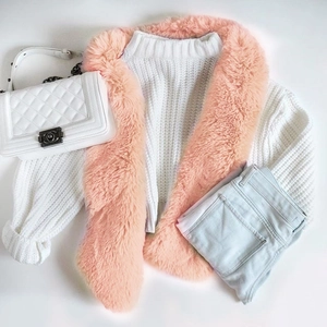 Dettaglio collo in ecopelliccia rosa su maglione bianco per outfit invernali