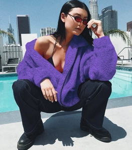 Detail of a purple faux fur zip-up jacket featuring a warm stand collar and soft texture