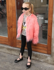 Detail of pink faux fur coat paired with striped Donald Duck tee and split-leg pants