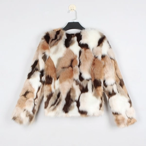Détail de la veste en fausse fourrure avec patchwork de couleurs crème, café et camel