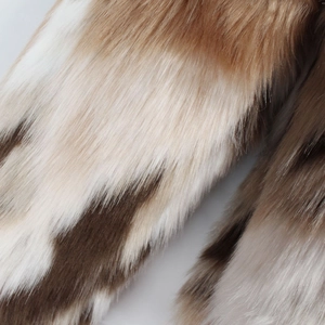 Gros plan macro montrant la texture épaisse de la fausse fourrure en tons marron et blanc