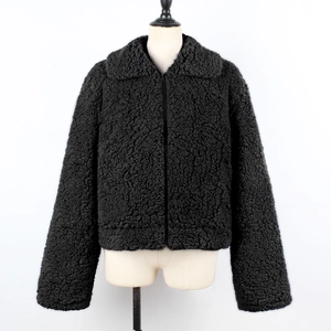 Detail of black faux shearling jacket featuring a full zip closure and turn-down collar
