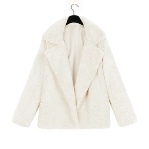 Close-up of white plush teddy coat featuring wide lapels and soft fleece texture