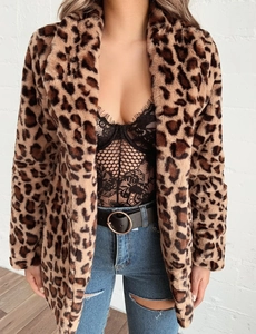 Détail d'un manteau en fausse fourrure léopard avec body en dentelle et un jean