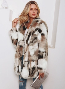 Detailed texture of multi-color faux fur coat with white brown and grey patchwork