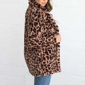 Vue latérale du manteau en fausse fourrure léopard avec col tailleur et texture peluche