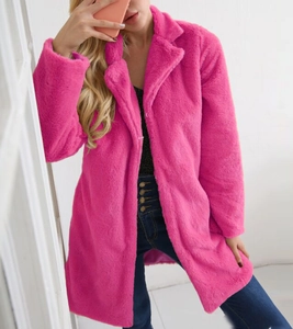 Gros plan du manteau en fausse fourrure rose vif avec revers large et texture peluche