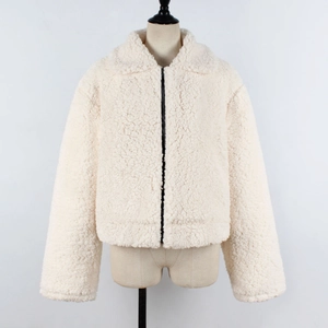 Detail of cream faux shearling jacket featuring contrast black zipper and plush teddy texture