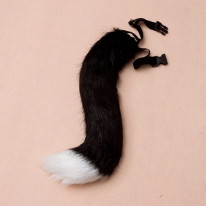 Detailed close-up of a plush faux fur fox tail with adjustable strap and plastic buckle