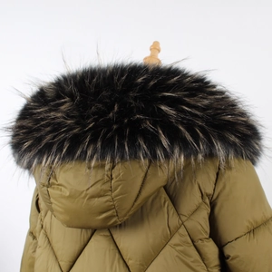Détail d'une parka matelassée vert olive avec un col en fausse fourrure noire épais et touffu