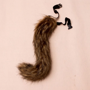 Detail of faux fur fox tail with adjustable black elastic strap and plastic buckle closure