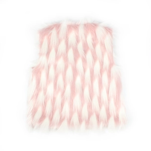 Détail de la texture en fausse fourrure rose et blanche à motif d'écailles sur le gilet