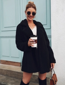Detailed view of women's black teddy fur coat with wide lapels for autumn and winter fashion