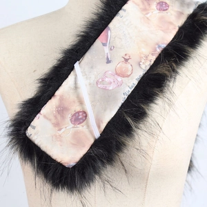 Détail d'un col en fausse fourrure noire avec doublure en soie à motifs et texte chic