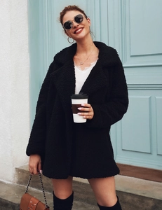Detail shot of a stylish black faux fur mid-length coat with a large lapel collar for women