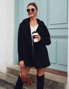 Detailed street style of black fleece coat with white lace top and over-the-knee boots