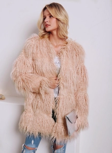 Détail du manteau en fausse fourrure duveteuse avec jean et pochette en croco gris