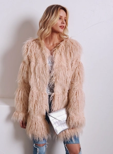 Texture détaillée du manteau en fausse fourrure duveteuse abricot avec peluche à franges