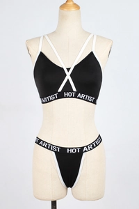 Détail d'un ensemble lingerie de sport noir avec élastiques et imprimé HOT ARTIST