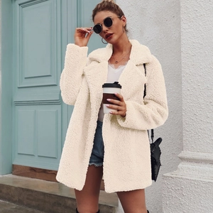 Detail of cream teddy coat with notched collar and fluffy texture on street model