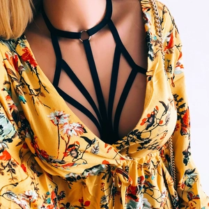 Sexy black elastic body harness bra with silver metal ring over a floral dress