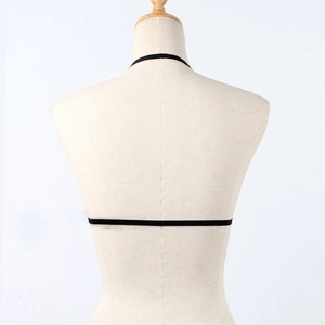 Detail view of black strappy elastic bra top back design on a beige mannequin