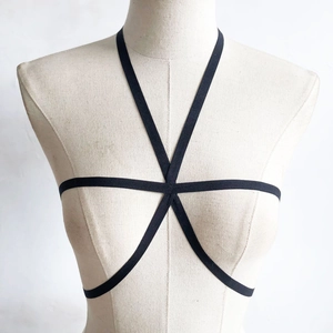Dettaglio frontale del corpo elastico nero a forma di pentagramma su manichino beige
