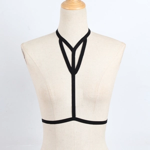 Detail of a black elastic strap harness on a mannequin showing geometric chest design